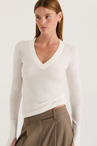 Close up view of a model wearing a white long-sleeve top on a white background