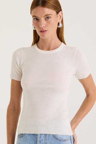Model wearing a cream fitted t-shirt on a white background