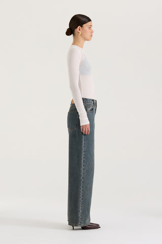 Side view of model wearing graphite wash wide leg and low rise Henne Gisella Jeans on a white background