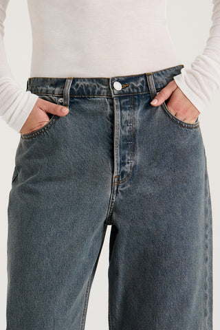 Close up view models waistband wearing graphite wash wide leg and low rise Henne Gisella Jeans on a white background
