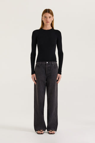 Model wearing black wash wide leg, low rise Jeans with a black long sleeve top on a white background 
