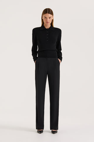 Model wearing high rise wide leg pants and a black long sleeve knit on a white background