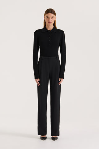 Model wearing high rise wide leg pants and a black long sleeve knit on a white background