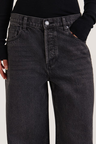 Close up view of models waistband wearing black wide leg jeans on a white background