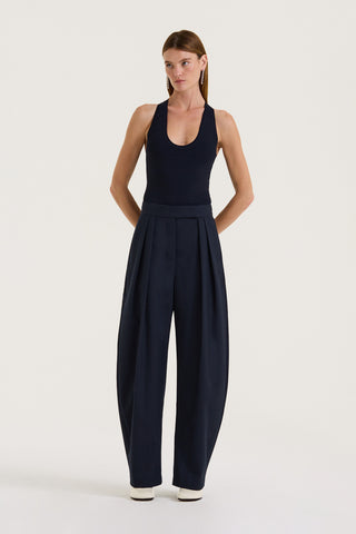 Model wearing a Navy tank top and Navy wide-leg pleated pants on a white background