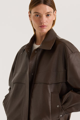 Model wearing a chocolate leather effect jacket against a white background