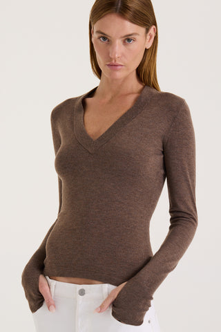 Model wearing a chocolate long-sleeve top on a white background