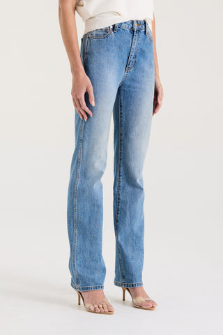 Model wearing blue high rise, straight leg jeans on a white background