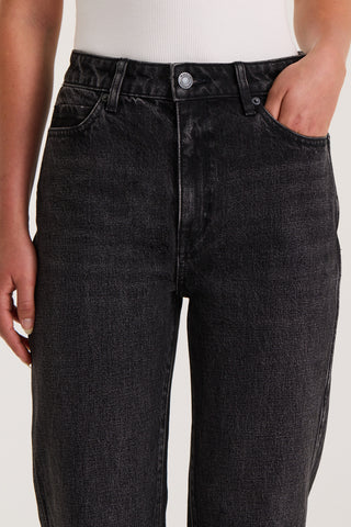 Close up view of models waistband wearing black slim fitted jeans on a white background