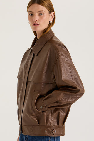Model wearing a brown leather effect jacket on a white background