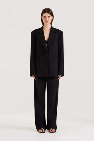 A model wearing a black Blazer with matching black pants on a white background