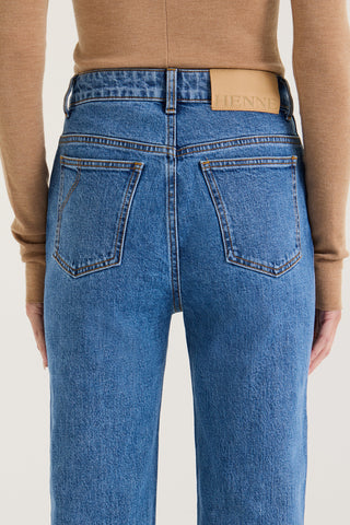 Close up back view of model wearing indigo wash Jeans with a Henne leather patch on a white background