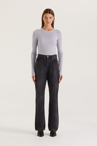 Model wearing black wash, straight leg and high rise jeans with a grey long sleeve top on a white background.