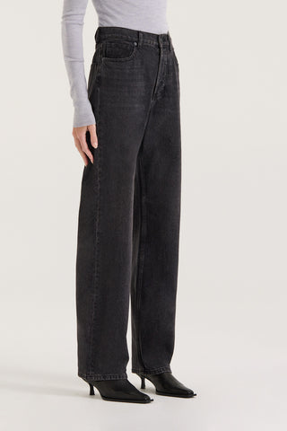 Close up view of model in black wash Jeans, with a high rise and straight leg, on white background.